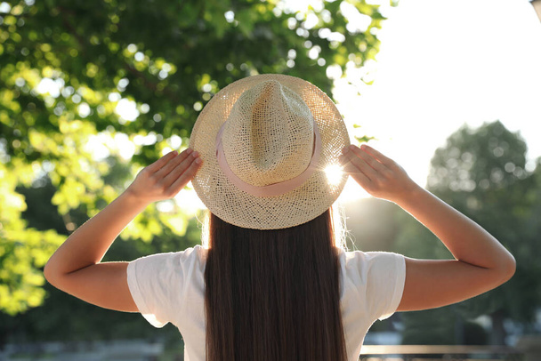 Young woman in hat outdoors on sunny day, back view - Photo, Image