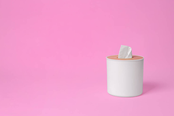 Holder with paper tissues on pink background. Space for text - Foto, imagen