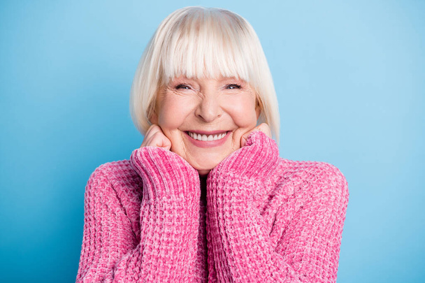 Photo of satisfied aged person smile holding hands on cheeks wear sweater isolated on blue color background - Foto, Imagem