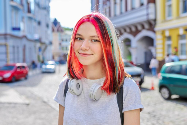 Fashionable beautiful girl teenager in wireless headphones with bright dyed colored hairstyle - Photo, Image