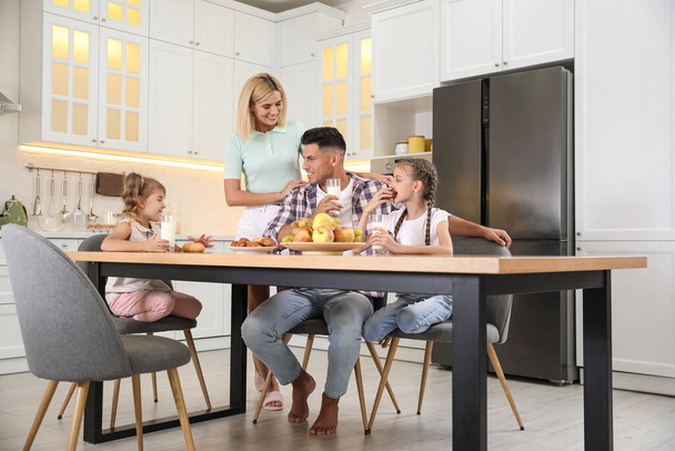 Happy family eating together at table in modern kitchen - Fotoğraf, Görsel