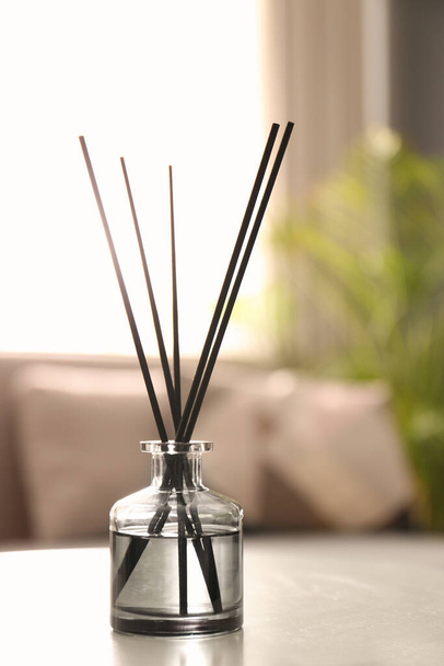 Aromatic reed air freshener on white table in room - Zdjęcie, obraz