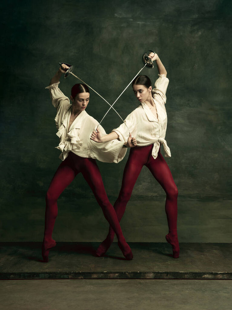 Two young female ballet dancers like duelists with swords. Ballet and contemporary choreography concept. Creative art photo. - Foto, immagini