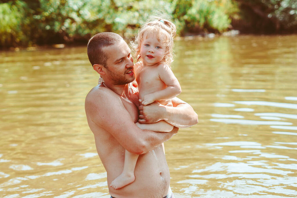 liefhebbende vader en kind hebben plezier ondersteboven in de rivier - Foto, afbeelding