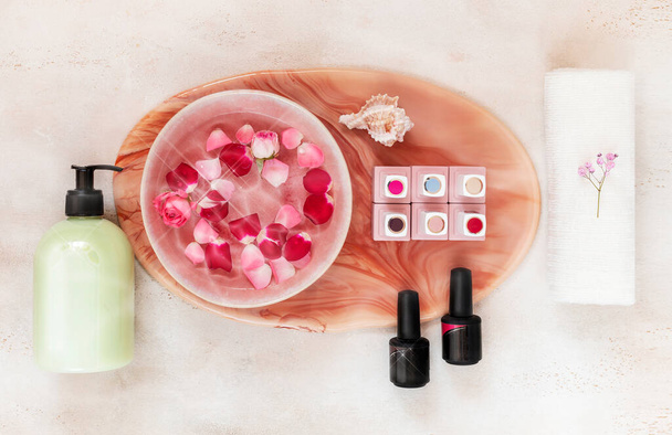 Jars of nail Polish, a jar of cream and a bath of nourishing water with rose petals - 写真・画像