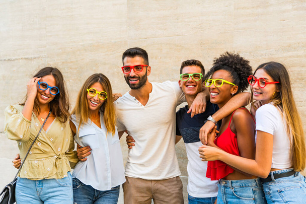 Jovens felizes segurando óculos falsos se divertindo. Foto e carnaval engraçado conceito acessórios. - Foto, Imagem
