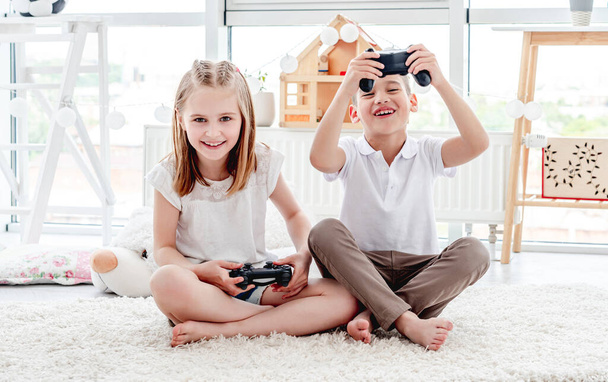 Playful kids with joysticks for gaming - Fotó, kép