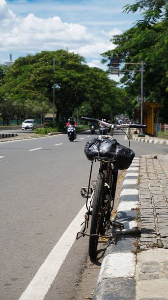 La bicicleta está apoyada contra el divisor de carreteras - Foto, Imagen