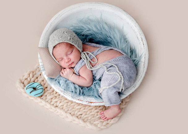 Cute newborn sleeping in round cradle - Photo, image