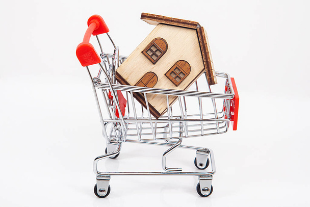Real estate agent concept. House model inside shopping cart. - Photo, Image