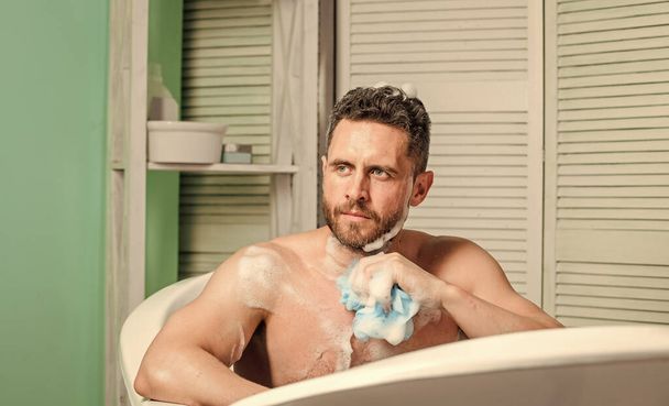 stay clean and fresh. personal care. Sexy man in bathroom. hygiene and health. Morning shower. macho man washing in bath. man wash muscular body with foam sponge. My relaxation - 写真・画像