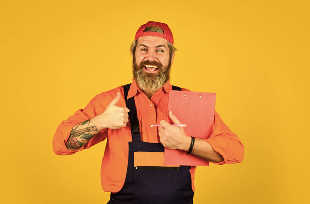 Check list. Control concept. Courier with document. Waybill or delivery note. Delivery service. Bearded storekeeper. Supplier of goods. Delivery man in cap holding clipboard looking information - Foto, Imagem
