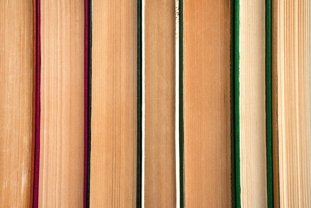 Fondo del libro, una pila de libros presionados uno contra el otro. Vista lateral. El concepto de educación. - Foto, imagen