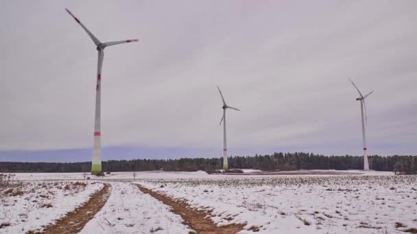 Časová prodleva větrné farmy v zimě. Časová prodleva rotujících větrných turbín na zasněženém poli v Německu. - Záběry, video