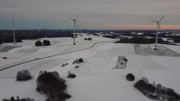 Letecký pohled na větrnou farmu v zimě. Letecký pohled na rotující větrné turbíny na zasněženém poli v Německu. - Záběry, video
