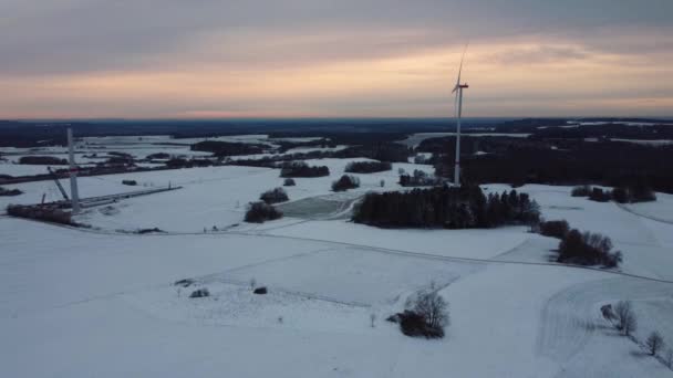 Widok z powietrza na farmę wiatrową w zimie. Widok z lotu ptaka obracających się turbin wiatrowych na zaśnieżone pole w Niemczech. - Materiał filmowy, wideo