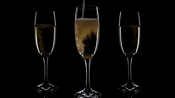 Tre bicchieri di champagne su sfondo nero. - Filmati, video