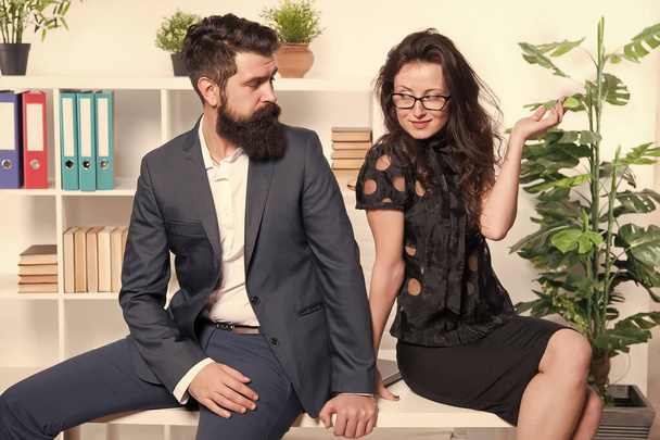Table top review. Business couple sit on office desk. Staff meeting. Formal meeting. Bearded man and sexy woman in formalwear. Business meeting. Meeting appointment. Job interview. Holding workshop - Zdjęcie, obraz