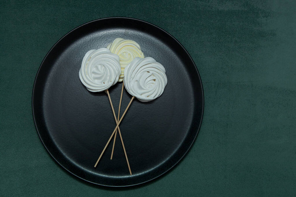 Zephyr or Marshmallow on black plate. Top view, copy space. Beautiful Meringues on stick or  original sweet bouquet of Valentine's or Mother's Day. Homemade low-calorie dessert. - Photo, Image