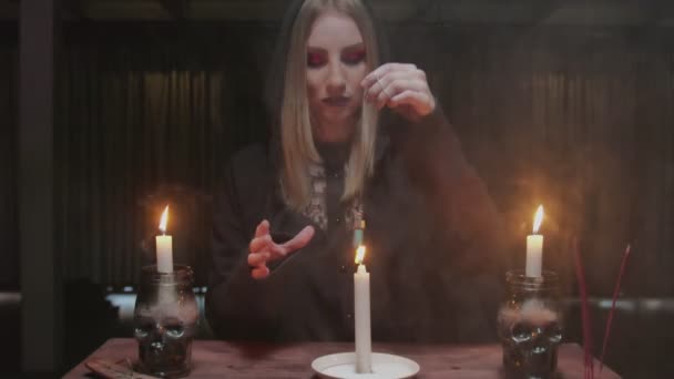 Joven bruja adivina utiliza un cristal mágico azul y vela en el futuro ritual revelador - Metraje, vídeo