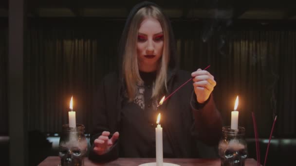 Nuori noita nainen ennustaja käyttää kynttilän ja suitsukkeen tikku tulevaisuudessa kertoo rituaali - Materiaali, video