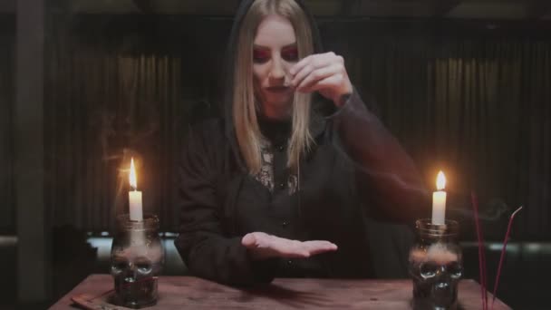 Jeune sorcière diseuse de bonne aventure utilise aiguille avec fil pour divination magique rituel - Séquence, vidéo