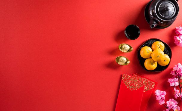 Chinese nieuwjaar festival decoraties pow of rood pakket, oranje en gouden ingots of gouden brok op een rode achtergrond. Chinese karakters FU in het artikel verwijzen naar geluk, rijkdom, geldstroom. - Foto, afbeelding