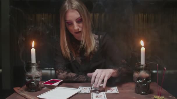 Young witch female fortune teller uses tarot card, dices and tablet to read future - Footage, Video