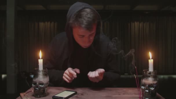 Skoncentrowany tajemniczy czarodziej męska fortuna używa kości i telefonu do odczytywania przyszłości - Materiał filmowy, wideo