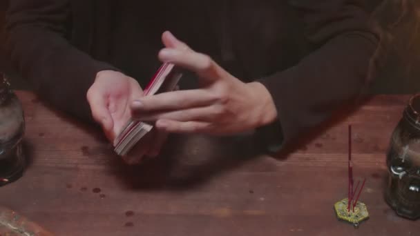 Zblízka tajemný kouzelník muž věštkyně zamíchejte karty a připravte je na budoucí vyprávění - Záběry, video