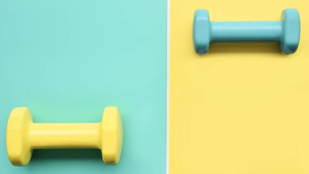 close up of dumbbell on green and yellow background - Fotó, kép