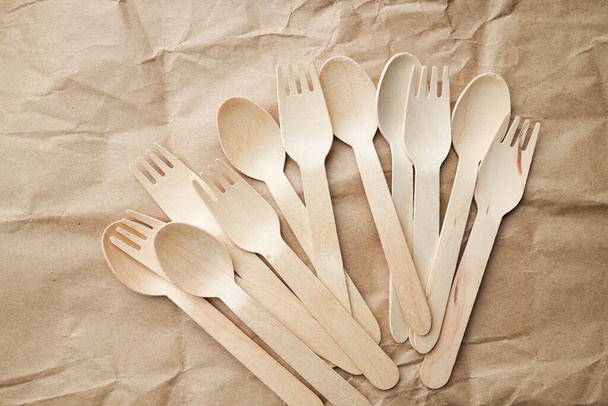 eco friendly disposable kitchenware utensils on paper background. look from above. wooden forks. eco friendly concept. copy space - Fotoğraf, Görsel