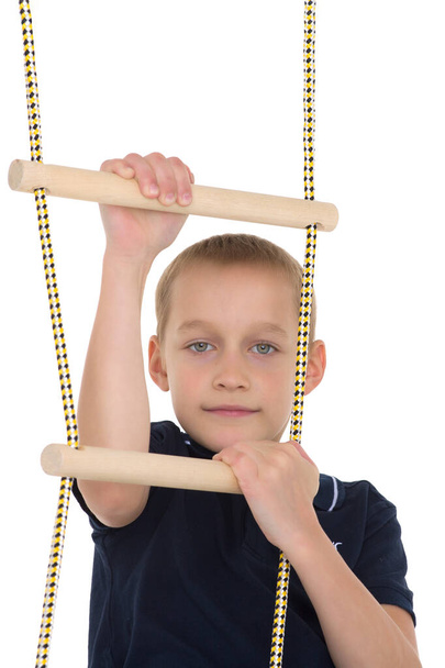 Teenage boy climbiing on rope ladder - Фото, зображення