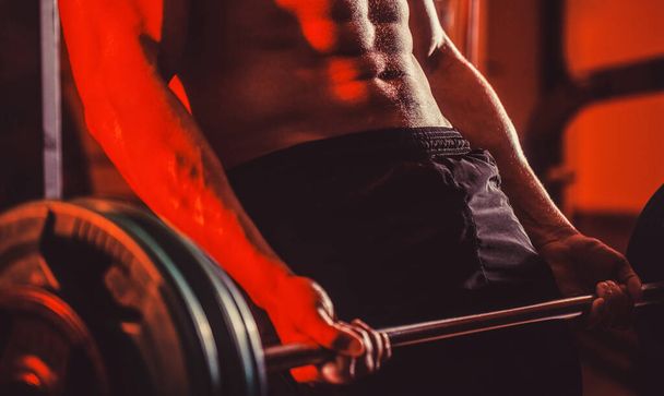Closeup deadlift barbells workout. Sporty man lifts barbell in gym. Close up training with barbell - 写真・画像