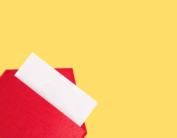 Red open envelope with a sheet of paper mock up on a yellow background with copyspace and mock up. Valentine's day holidays concept and love notes, christmas and new year  letters for Santa Claus - Zdjęcie, obraz