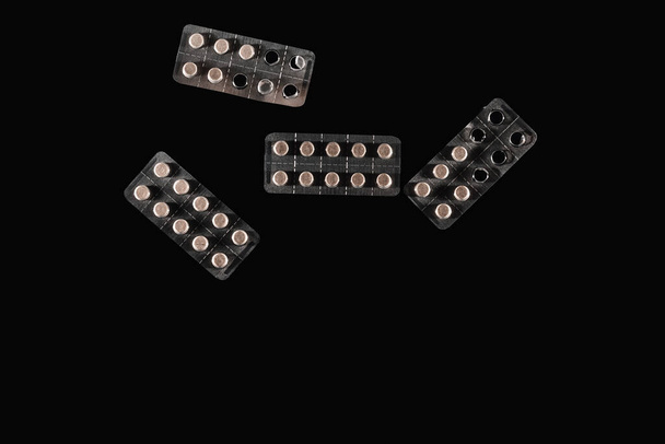Tabletki w aluminiowych opakowaniach odizolowane na czarnym tle  - Zdjęcie, obraz