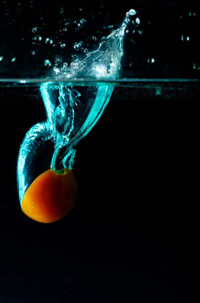Salpicadura de agua de tomate sobre fondo negro
  - Foto, imagen