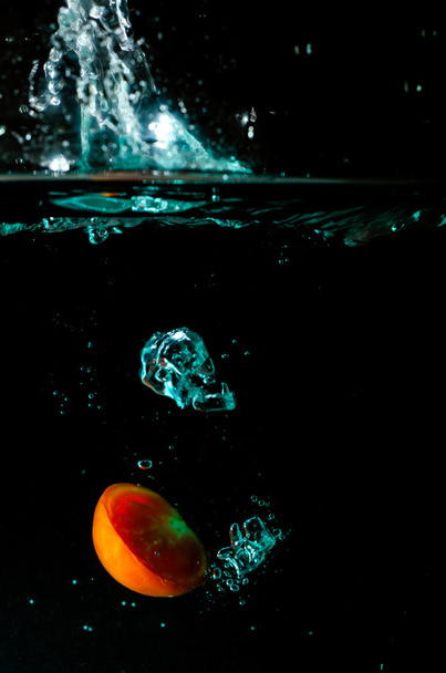 paradicsom víz splash-fekete háttér  - Fotó, kép