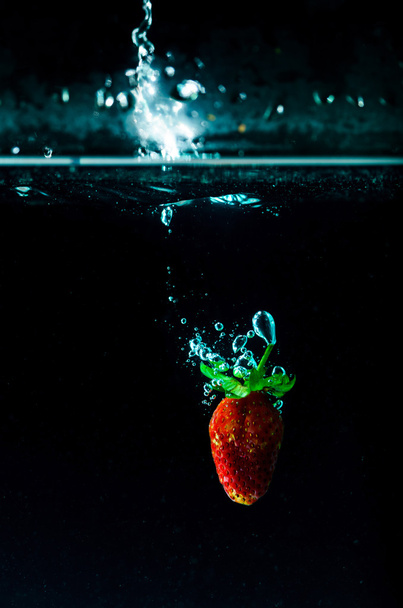 salpicadura de agua de fresa sobre fondo negro
  - Foto, imagen