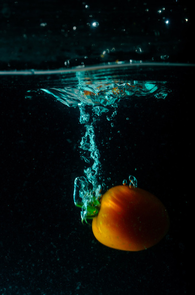 tomaat water splash op zwarte achtergrond  - Foto, afbeelding