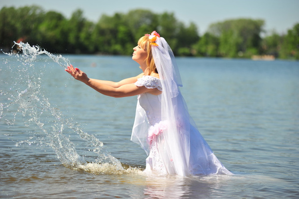 bride dressed in wedding gown in water - Foto, Bild