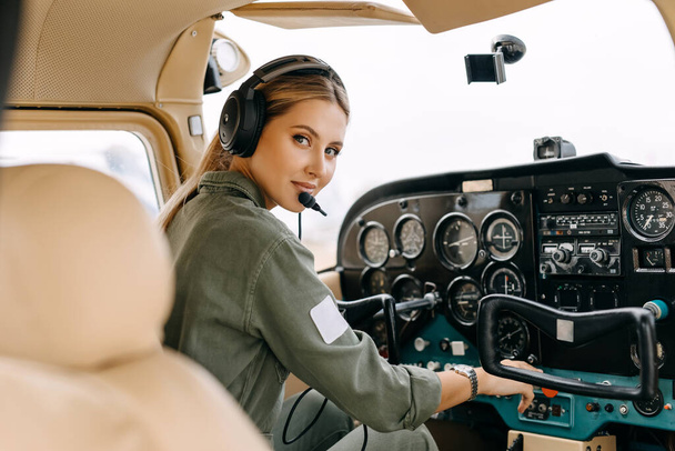 muotokuva kaunis blondi lentäjä istuu sisällä lentokone - Valokuva, kuva