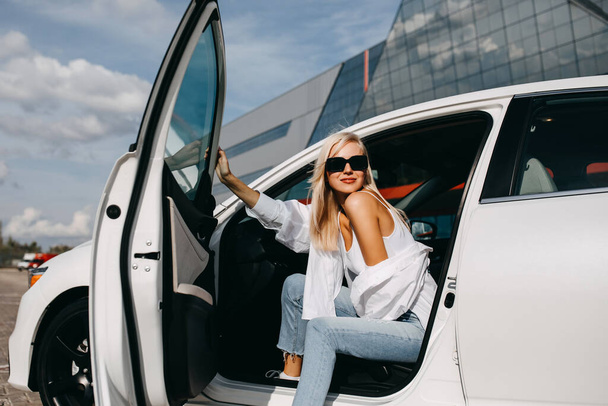 beautiful young woman sitting in her car on parking - Foto, afbeelding