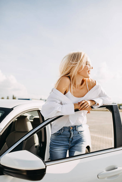 kaunis nuori nainen seisoo autonsa edessä pysäköinti - Valokuva, kuva