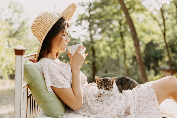 ritratto di bella donna che si rilassa nella foresta con il suo piccolo gatto carino - Foto, immagini