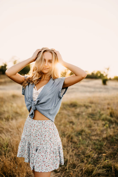 portrait of beautiful young woman in stylish clothes on nature in evening - Foto, imagen