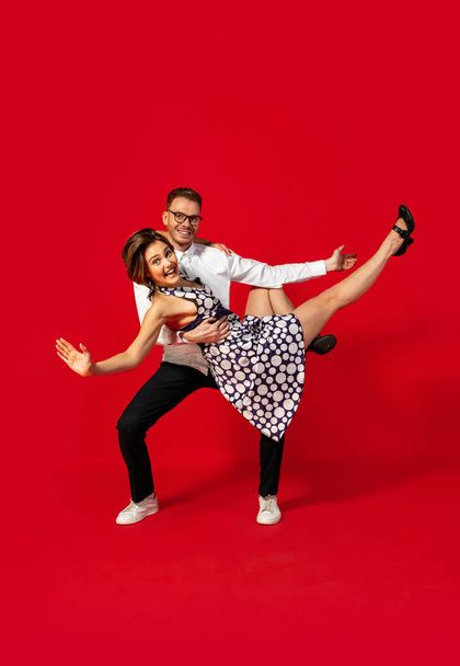 Old-school fashioned young couple dancing isolated on red background - Fotografie, Obrázek