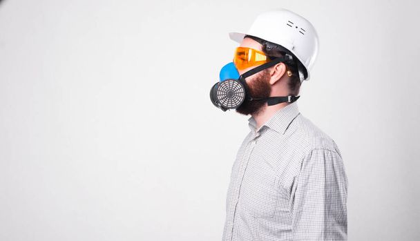 Zdjęcie profilowe mężczyzny w koszuli w białym hełmie i oddychającego przez respirator - Zdjęcie, obraz