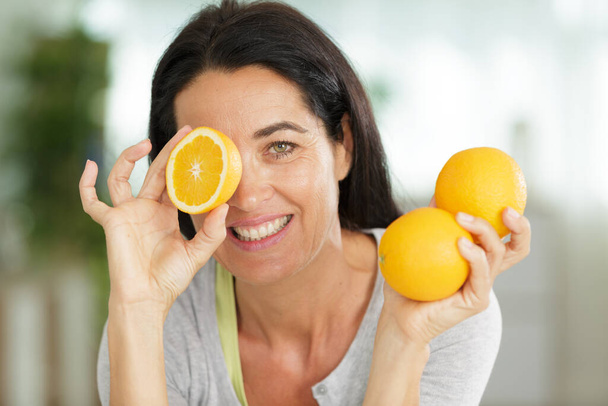 portrait of woman with orange fruits - Fotó, kép
