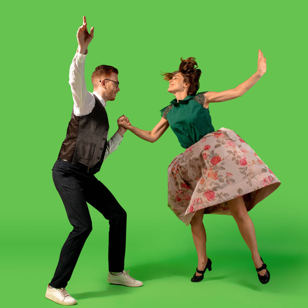 Old-school fashioned young woman dancing isolated on green background - Foto, Imagen